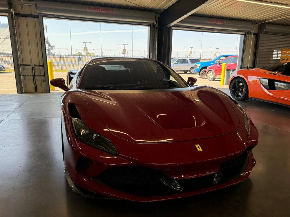  A red sports car displayed inside a luxury garage